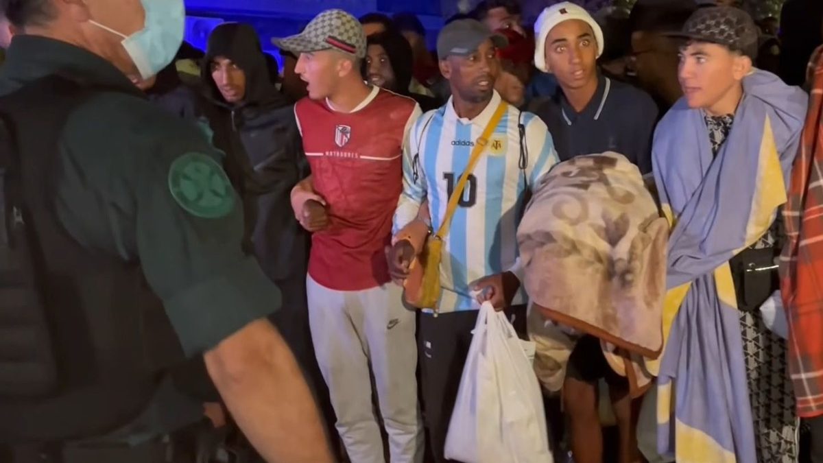 Una avalancha de migrantes se salta el cordón policial y crea el caos durante el traslado de las playas al puerto de Ce…