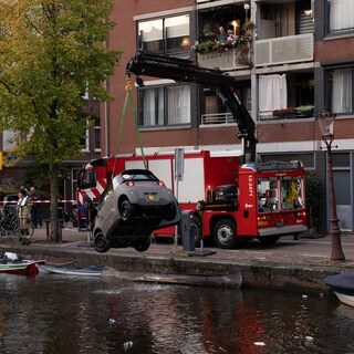 Mini-auto belandt in Lijnbaansgracht, bestuurder ongedeerd