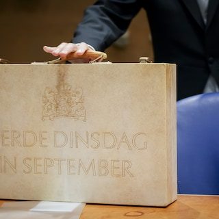 Minister van Financiën overhandigt koffertje aan Tweede Kamer